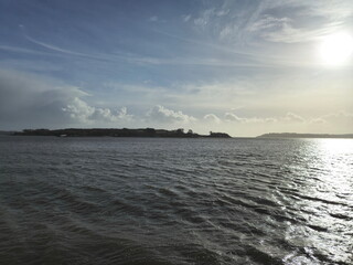 Spike Island in Ireland as it is seen from another island, with ocean waters and cloudy sky