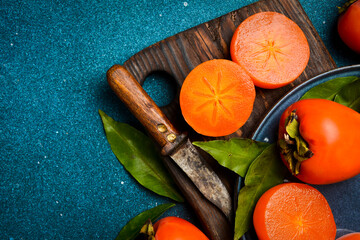 Close-up, Sliced ​​persimmon fruits on a wooden cutting board. Close-up. Rustic style, on a...
