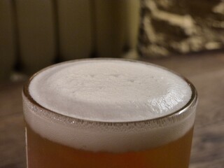 Chilled Beer in Drinkware with Foam on Tableware