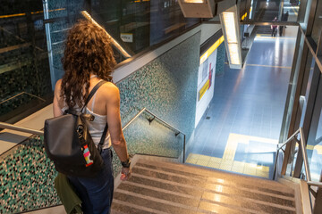 Mid-adult woman descending steps in a subway station