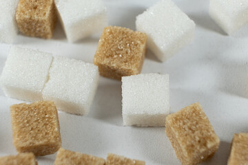 Cubes of unrefined brown demerara sugar and white refined beet sugar.