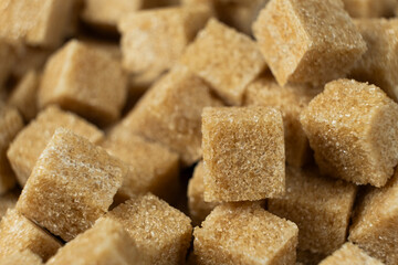 Macro cubes of brown cane unrefined dry demerara sugar.