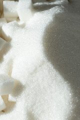White refined beet sugar in the form of crystals and cubes.