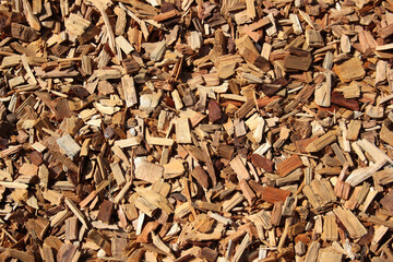 A textured background of wooden chips and bark fragments, commonly used in mulching for landscaping and gardening