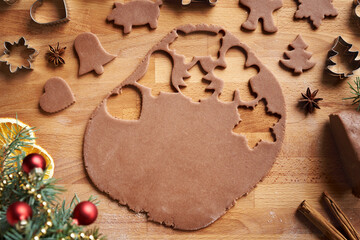 Cutting out shapes from rolled out pastry dough - preparation of homemade gingerbread Christmas cookies