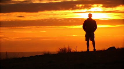 Fototapeta premium Silhouette of a Man Against a Sunset Sky
