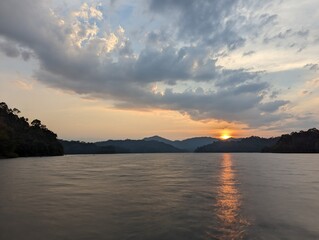Fototapeta premium Orange sunset with clouds sky and beautiful water in Thailand