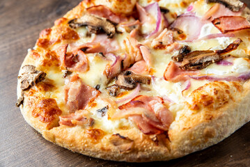 Delicious freshly baked pizza topped with ham, mushrooms, and red onions, featuring a golden crust and melted cheese. Perfect for food lovers and culinary enthusiasts.