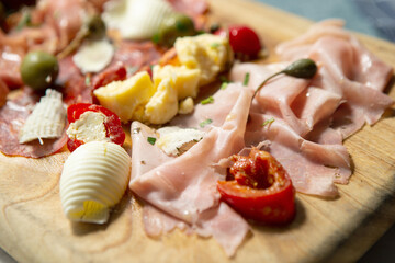 Prosciutto, olives and cheese on a cutting board
