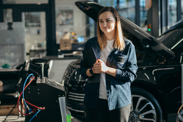 Female inspector checks the work of a mechanic in a car repair shop