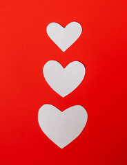 White paper hearts on red background for happy valentines day