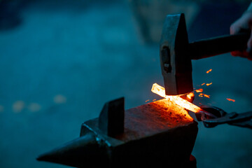 a blacksmith's hammer strikes molten iron, the work of a blacksmith