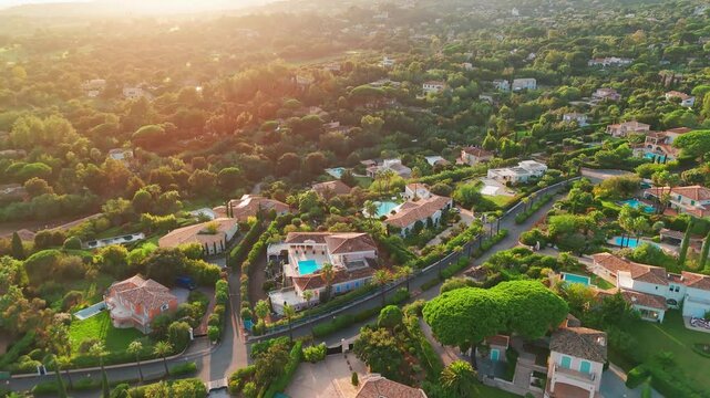 Aerial view of luxury villas with pools and gardens on the French Riviera at sunset