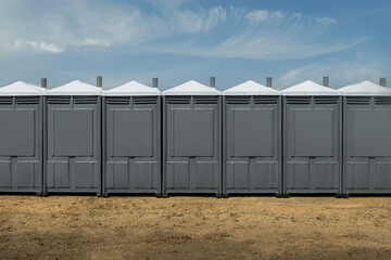 Backsides of Grey Porta Potties in Line