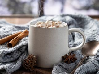 Steaming cup of hot chocolate wrapped in a blanket