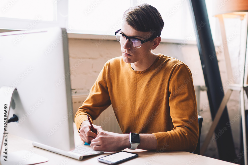 Aufkleber young hipster guy in spectacles watching important webinar on web page internet via modern computer 