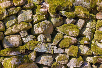 Old stone wall with green moss