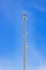 Radio mast with antennas at a clearless blue sky