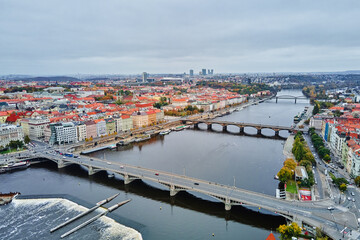 Fototapeta premium Panoramic aerial view of European city with multiple bridges over river, colorful historic buildings. Cityscape of Prague, Czech Republic