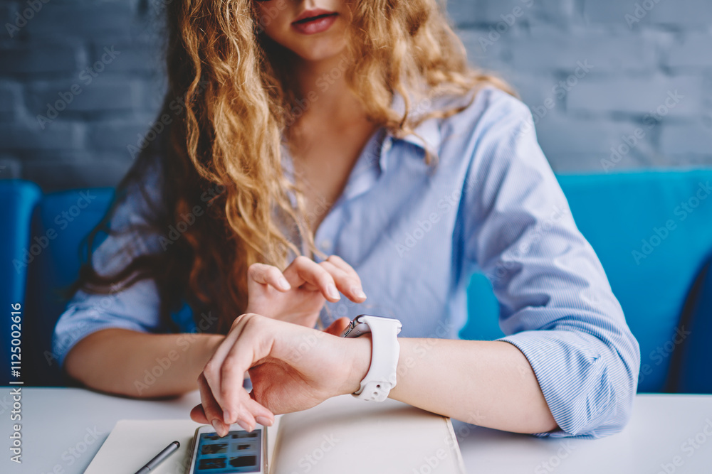 Poster cropped image of female journalist checking time on modern display of smartwatch while waiting for m