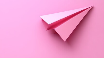 Pink paper airplane on a solid pink background