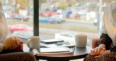 Two individuals engaged in a lively discussion over coffee, surrounded by a vibrant bustling city backdrop. No face people. Space for text.