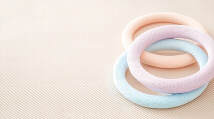 Fototapeta premium A serene composition featuring pastel-colored rings laid on a soft background, perfect for minimalist aesthetics.