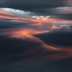 The sky is filled with dark, ominous clouds that are illuminated by the warm orange and pink hues of the setting sun. The clouds are scattered across the sky, creating a dramatic and moody atmosphere.