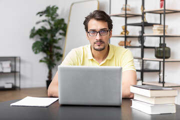 Young handsome man in headphones studying online at home. Distance education concept	