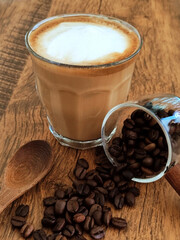 Hot latte with coffee beans on a wooden table