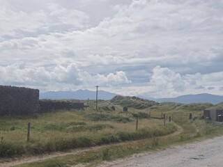 Mountain Landscape with Clouds and Grass Along a Roadway