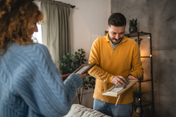 husband and wife dusting photo frame in the living room