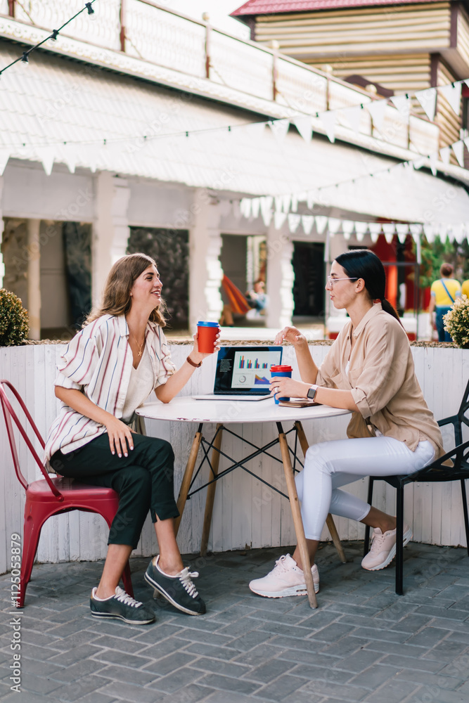 Poster side view of caucasian remote workers sitting at outdoors table and discussing business project for 