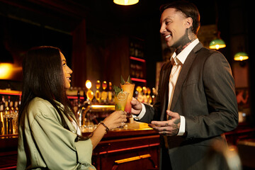 Young couple shares a special moment over cocktails, celebrating their connection in style.