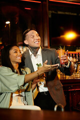 Young couple celebrates their relationship with drinks during a fun night out.