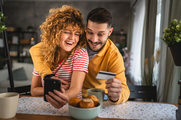 husband and wife on breakfast buy online on cellphone and credit card