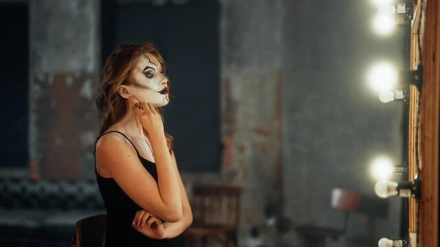 Sexy woman with split personality drawing another face on half of her face. Portrait of beautiful lady applying cosmetic on her skin for be better and more successful, hiding her true self from other