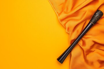 Naklejka premium A dramatic shot of an ebony hairstick with intricate designs resting on a silky fabric background