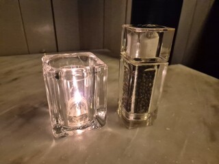 Candle and pepper on a restaurant table background
