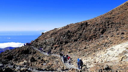 mehrere Wanderer steigen zum Gipfel des Vulkans Teide auf in Teneriffa auf bei herrlichem blauen Himmel