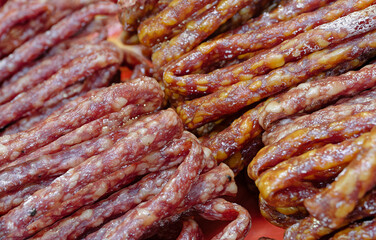 A large pile of thin smoked sausages