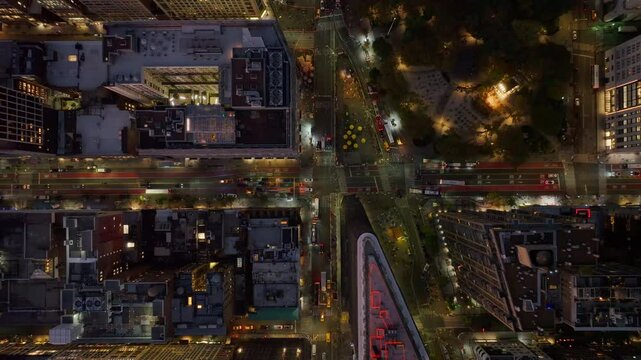 Tripod view from a unique crane perspective of traffic on a busy intersection at night in New York City,Madison Square Park in NoMad and Rose hill neighborhood