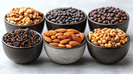 Delicious assortment of nuts and seeds in bowls, including almonds, black beans, and popcorn, perfect for healthy snacking or cooking