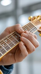 A close-up of a hand pressing guitar strings, showcasing fingers in action on the fretboard, highlighting musical talent and instrument detail.