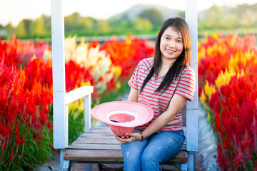 Portrait of beautiful asian girl in sunflower field at sunset. Beautiful asian woman in sunflower field at summer day.