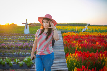 Portrait of beautiful asian girl in sunflower field at sunset. Beautiful asian woman in sunflower field at summer day.