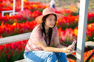 Portrait of beautiful asian girl in sunflower field at sunset. Beautiful asian woman in sunflower field at summer day.