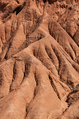 abstract natural background, red rugged sandstone. eroded soil close up. dry climate, erosion, canyon area