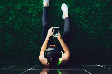 Top view of athletic female bodybuilder checking fitness news on sport website using 4g wireless...