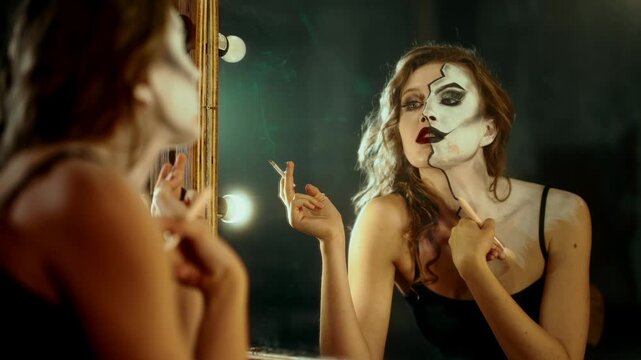 Attractive professional actress doing makeup and smoking in dressing room. Split personality and inner struggle, be yourself or another person for social acceptance, natural beauty and art makeup